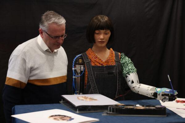 Aidan Meller looks at a painting by Ai-Da Robot, an ultra-realistic humanoid robot artist, during a press call at The British Library in London, England, on April 4, 2022. (Photo by Hollie Adams/Getty Images)