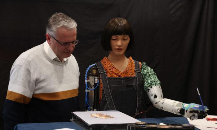 Aidan Meller looks at a painting by Ai-Da Robot, an ultra-realistic humanoid robot artist, during a press call at The British Library in London on April 4, 2022. (Hollie Adams/Getty Images)