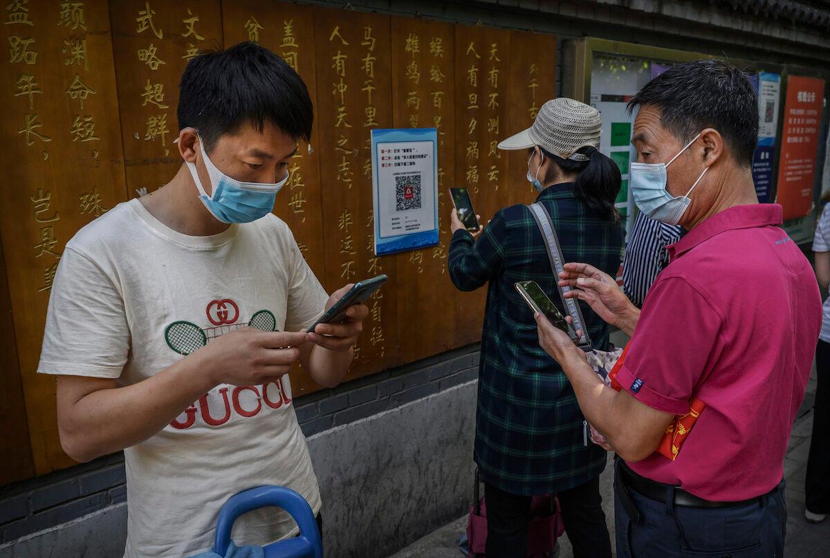 Chinese customers use the WeChat app to scan a health code before entering a local market on September 19, 2020 in Beijing, China. (Kevin Frayer/Getty Images)