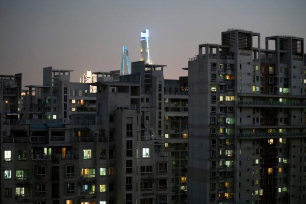 Buildings in a residential area near Zhoujiazui Road in Yangpu district light up at dusk in Shanghai on April 8, 2022. (Costfoto/Future Publishing via Getty Images)