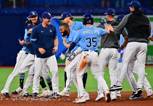 Manuel Margot #13 of the Tampa Bay Rays celebrates with teammates after hitting an RBI walk-off single in the 10th inning for a 9-8 win over the Oakland Athletics at Tropicana Field, in St Petersburg, Flor., on April 12, 2022. (Julio Aguilar/Getty Images)