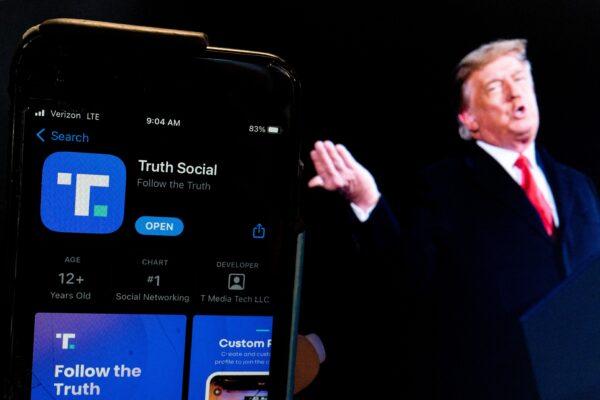 An image of former President Donald Trump next to a phone screen that is displaying the Truth Social app in Washington on Feb. 21, 2022. (Stefani Reynolds/AFP via Getty Images)