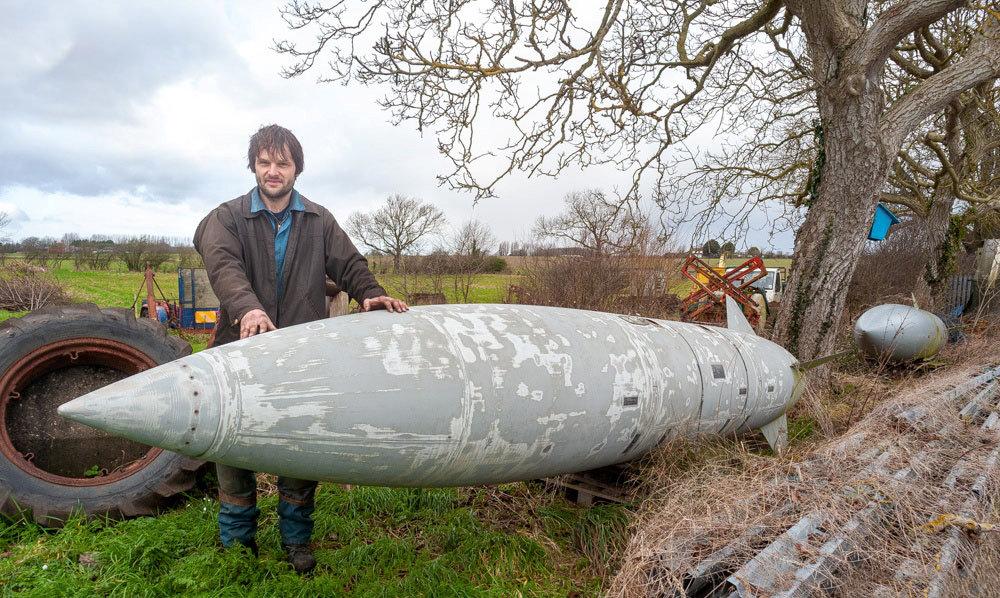Matt Thompson with the bomber jet tanks he keeps in his garden to help delivery drivers. (SWNS)