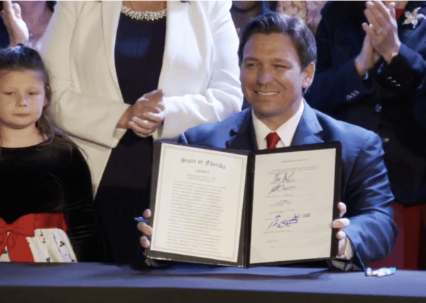 Florida Gov. Ron DeSantis displays the signed legislation that increases protections for unborn children. (Screenshot, Gov. Ron DeSantis Facebook Page)