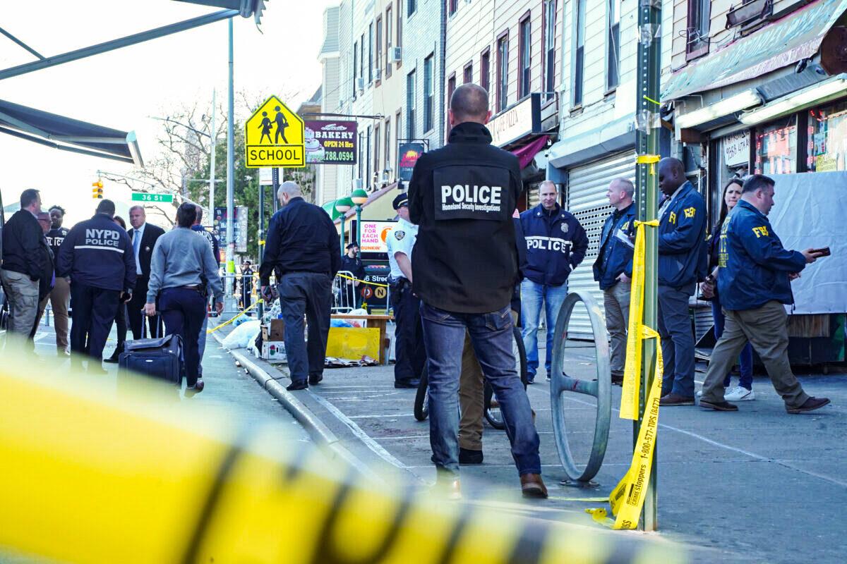 Officers investigate a shooting at the 36th Street subway station in Brooklyn, New York, on April 12, 2022. (Enrico Trigoso/The Epoch Times)