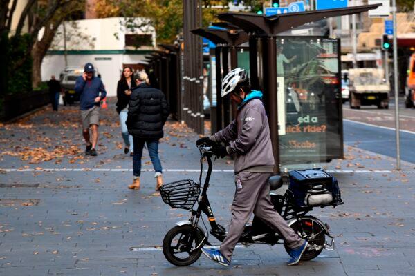 A courier crosses the road to deliver food in the central business district in Sydney, Australia, on May 14, 2020. (Saeed Khan/AFP via Getty Images)