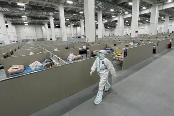 A staff member walks inside a makeshift hospital that will be used for Covid-19 coronavirus patients in Shanghai on April 7, 2022. (STR/AFP via Getty Images)