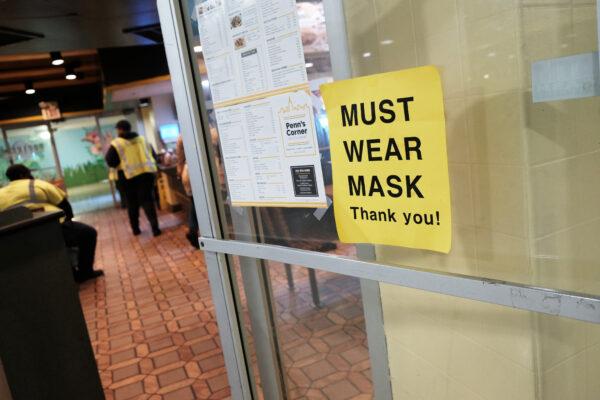 A sign on a door asks people to wear masks in downtown in Philadelphia, Penn., on April 15, 2022. (Spencer Platt/Getty Images)