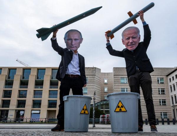 Peace activists wearing masks of Russian President Vladimir Putin (L) and newly elected U.S. President Joe Biden pose with mock nuclear missiles in front of the U.S. embassy in Berlin on Jan. 29, 2021. (John Macdougall/AFP/Getty Images)