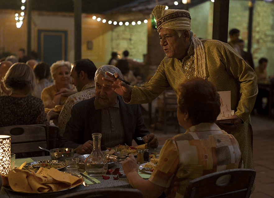Papa (Om Puri, standing, R) welcomes guests to his newly opened restaurant, in "The Hundred Foot Journey." (DreamWorks Pictures)