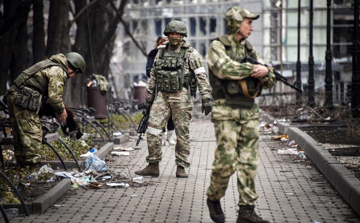 Russian soldiers walk along a street in Mariupol on April 12, 2022. (Alexander Nemenov/AFP via Getty Images)