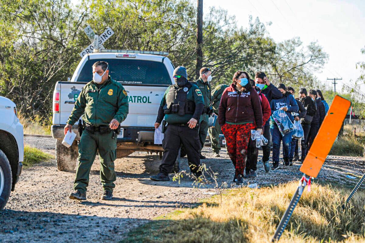 Border Patrol agents apprehend illegal immigrants after they cross the Rio Grande from Mexico into the United States, in La Joya, Texas, on Jan. 14, 2022. (Charlotte Cuthbertson/The Epoch Times)