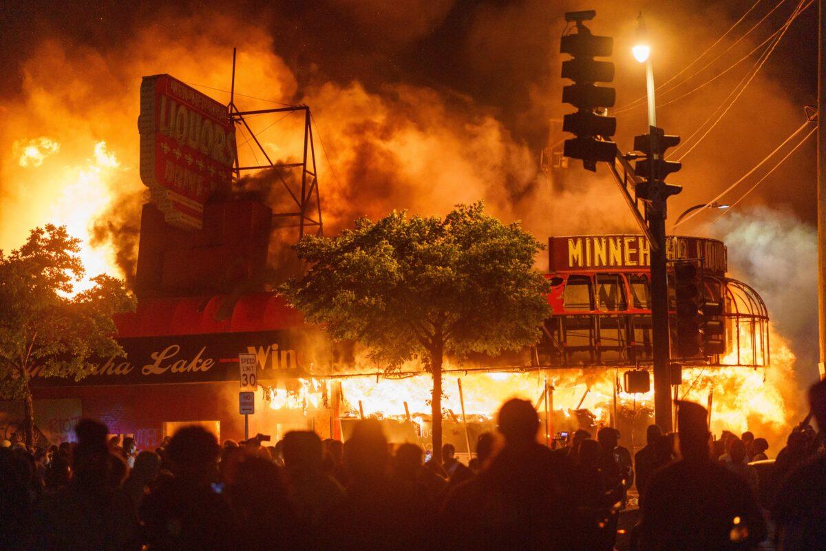 Protesters gather in front of a liquor store in flames near the Third Police Precinct in Minneapolis on May 28, 2020. (Kerem Yucel/AFP via Getty Images)