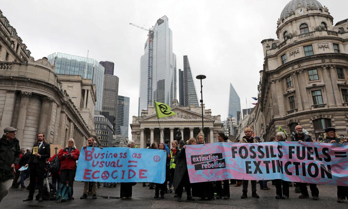 Activists hold banners as they protest outside the Bank of England (L) and Royal Exchange (C), during the eighth day of demonstrations by the climate change action group Extinction Rebellion, in London, on Oct. 14, 2019. (Isabel Infantes/AFP via Getty Images)
