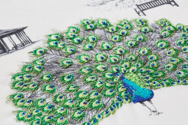Closeup of a hand-embroidered peacock in Susannah Weiland's "Green Kew Peacocks" design. (Yeshen Venema)