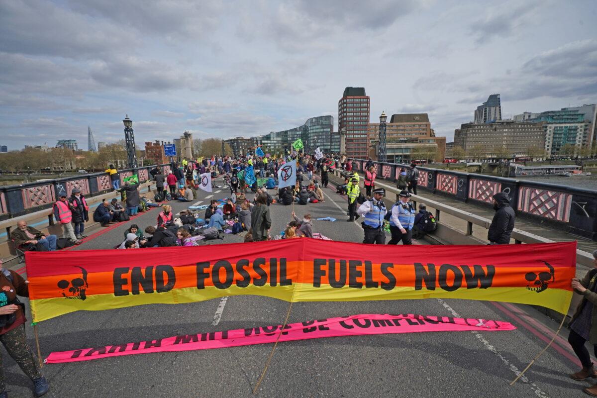 Activists unfurl a giant banner on Lambeth Bridge as they block it in protest over fossil fuel use, in London, in an undated file photo. (Yui Mok/PA)