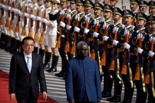 FILE - Chinese Premier Li Keqiang, left, and Solomon Islands Prime Minister Manasseh Sogavare review an honor guard during a welcome ceremony at the Great Hall of the People in Beijing, Wednesday, Oct. 9, 2019. (AP Photo/Mark Schiefelbein, File)