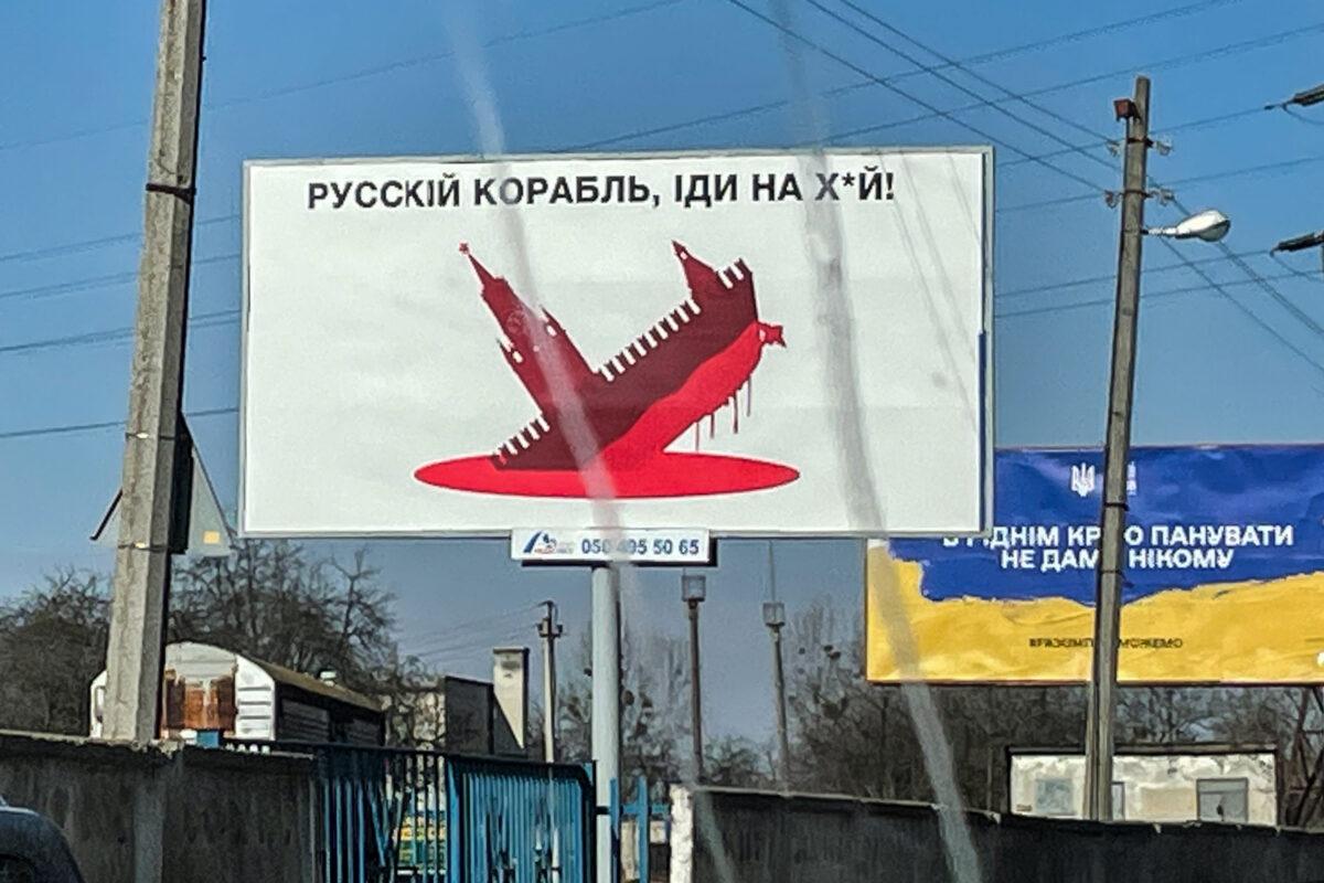 A billboard that features a ship stylized to look like the Kremlin sinking in a pool of blood, in western Ukraine, in March 2022. (Charlotte Cuthbertson/The Epoch Times)
