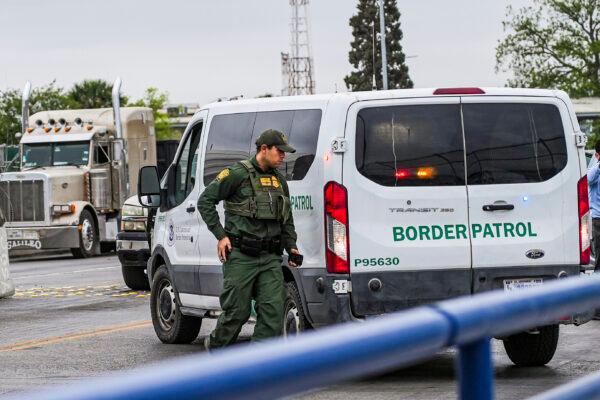 A Border Patrol agent prepares to drop a group of illegal immigrants being expelled under Title 42 at the halfway point of the international bridge between the United States and Mexico, in Eagle Pass, Texas, on April 19, 2022. (Charlotte Cuthbertson/The Epoch Times)