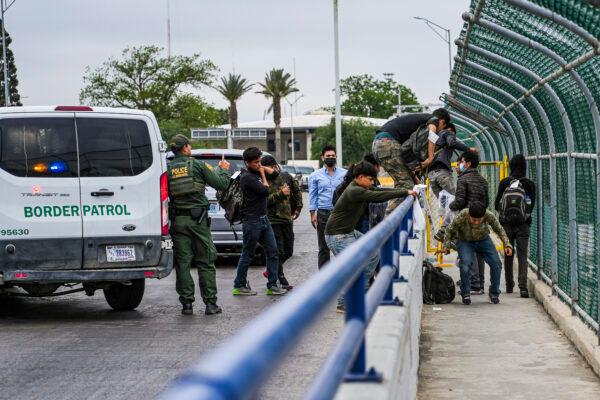A Border Patrol agent drops a group of illegal immigrants being expelled under Title 42 at the halfway point of the international bridge between the United States and Mexico in Eagle Pass, Texas, on April 19, 2022. (Charlotte Cuthbertson/The Epoch Times)