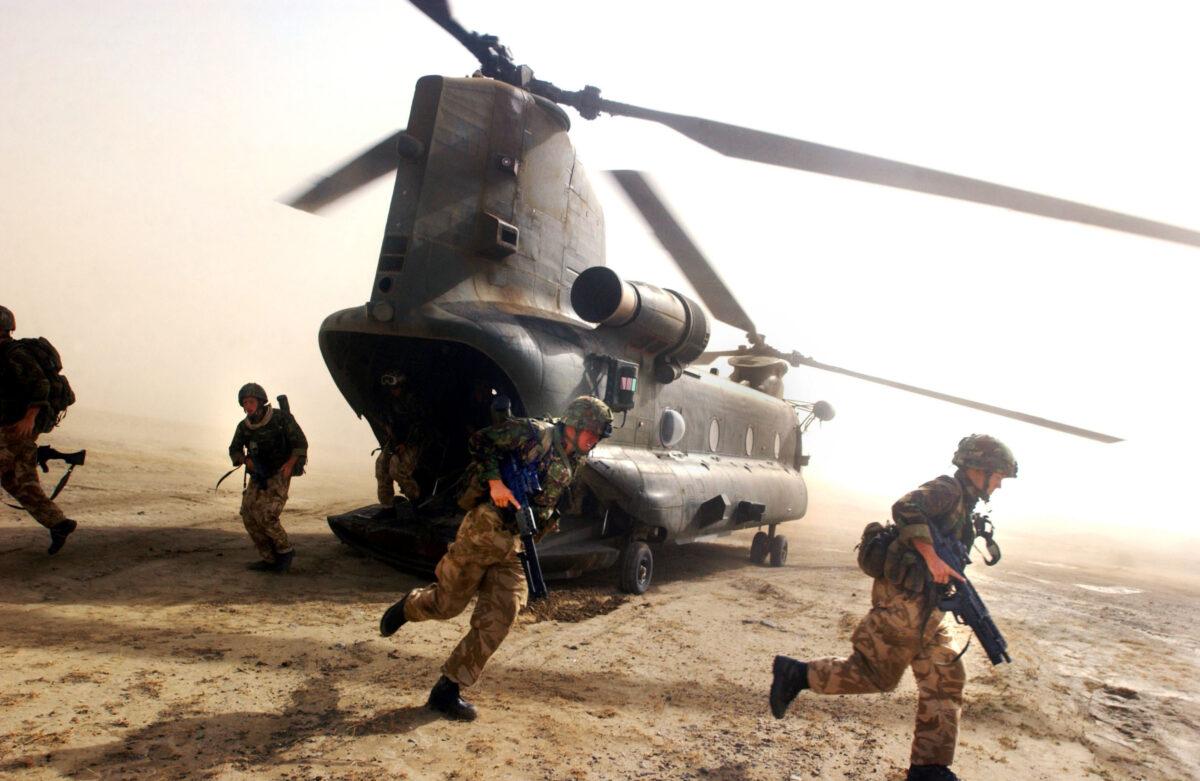 British Royal Marines of 45 Commando scramble out the back of a Chinook helicopter during an eagle vehicle checkpoint operation as part of the ongoing Operation Buzzard in southeastern Afghanistan on July 8, 2002. (Scott Nelson/Getty Images)