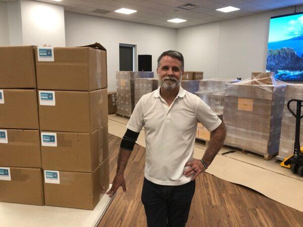Mark Minck stands with six pallets of petitions, readying materials before volunteers arrive to stuff petitions into envelopes on July 6, 2021, in Gainesville, Fla. (Courtesy of Mark Minck)