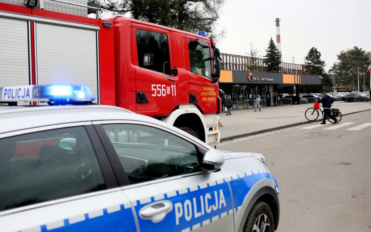 A police car and a firefighters' truck before the Pniowek coal mine in Pawlowice, southern Poland, on April 20, 2022, where two underground methane explosions killed five people early Wednesday. (AP Photo)