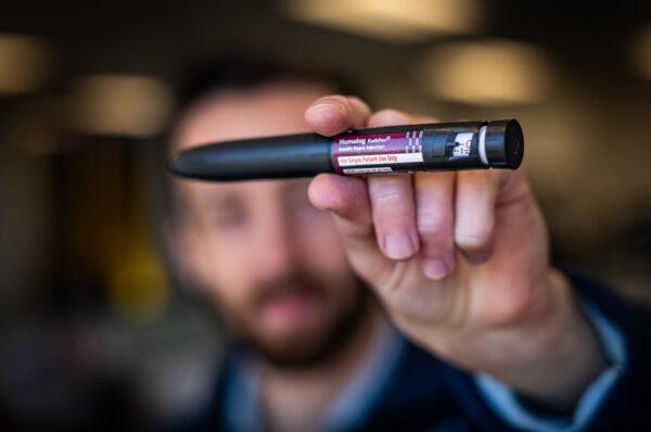 A man holds up a Humalog Insulin injection pen in Irvine, Calif., on March 24, 2022. (John Fredricks/The Epoch Times)