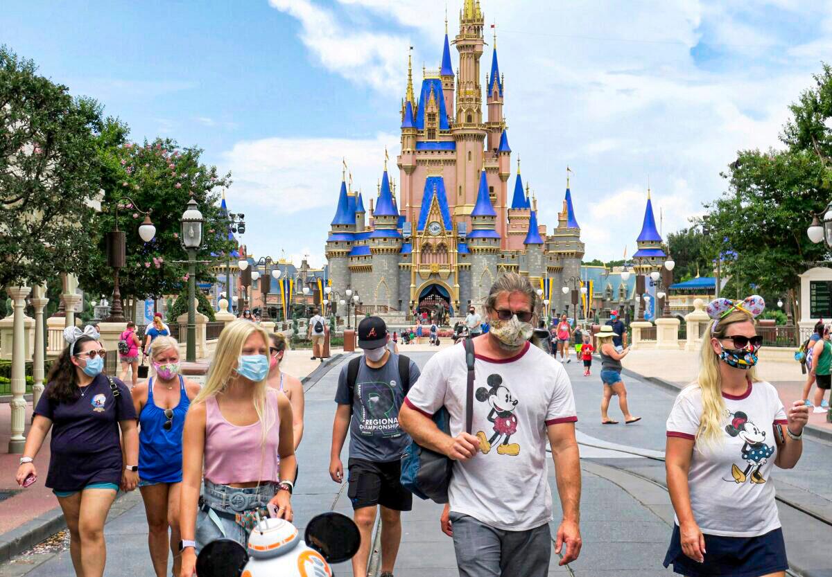 Guests wear masks, as required, to attend the official reopening of the Magic Kingdom at Walt Disney World in Lake Buena Vista, Fla, on July 11, 2020. (Joe Burbank/Orlando Sentinel via AP)