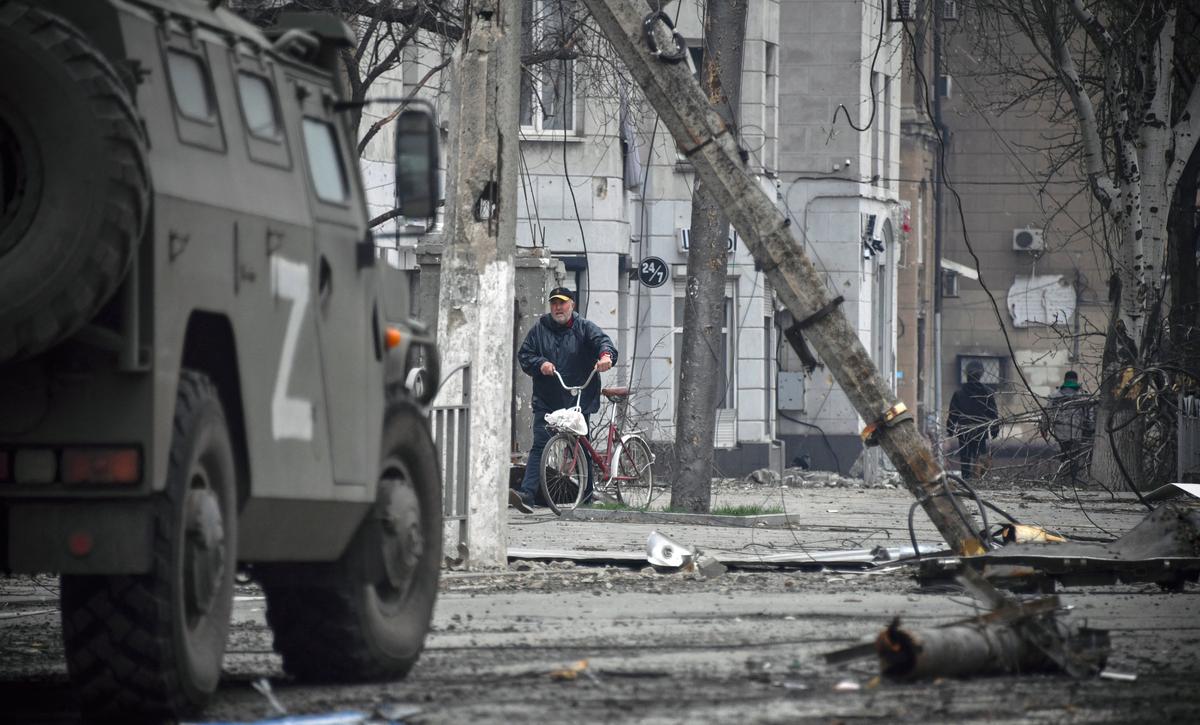 A man walks with a bicycle in central Mariupol on April 12, 2022. (Alexander Nemenov/AFP via Getty Images)