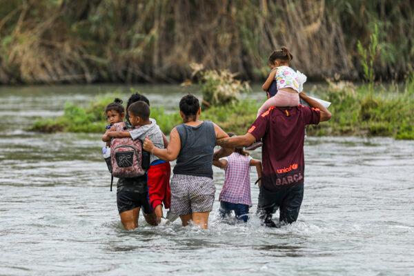 A group of Hondurans cross the Rio Grande toward Eagle Pass, Texas, from Piedras Negras, Mexico, on April 21, 2022. (Charlotte Cuthbertson/The Epoch Times)