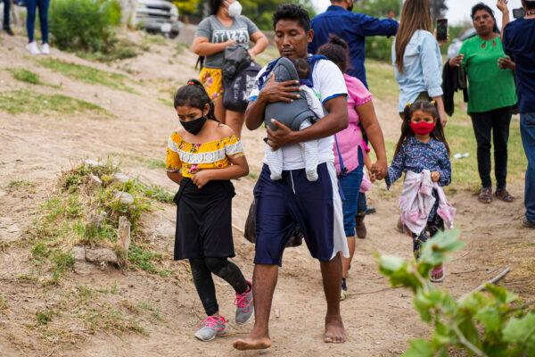 A group of Hondurans prepare to cross the Rio Grande into Eagle Pass, Texas, from Piedras Negras, Mexico, on April 21, 2022. (Charlotte Cuthbertson/The Epoch Times)