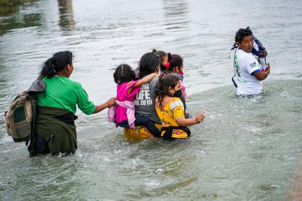 A group of Hondurans cross the Rio Grande toward Eagle Pass, Texas, from Piedras Negras, Mexico, on April 21, 2022. (Charlotte Cuthbertson/The Epoch Times)