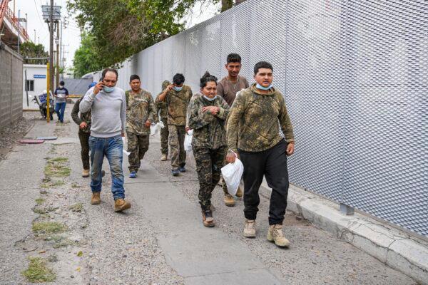 A group of Mexicans walk back into Mexico after being returned halfway along the international bridge from the United States under Title 42, in Piedras Negras, Mexico, on April 21, 2022. (Charlotte Cuthbertson/The Epoch Times)