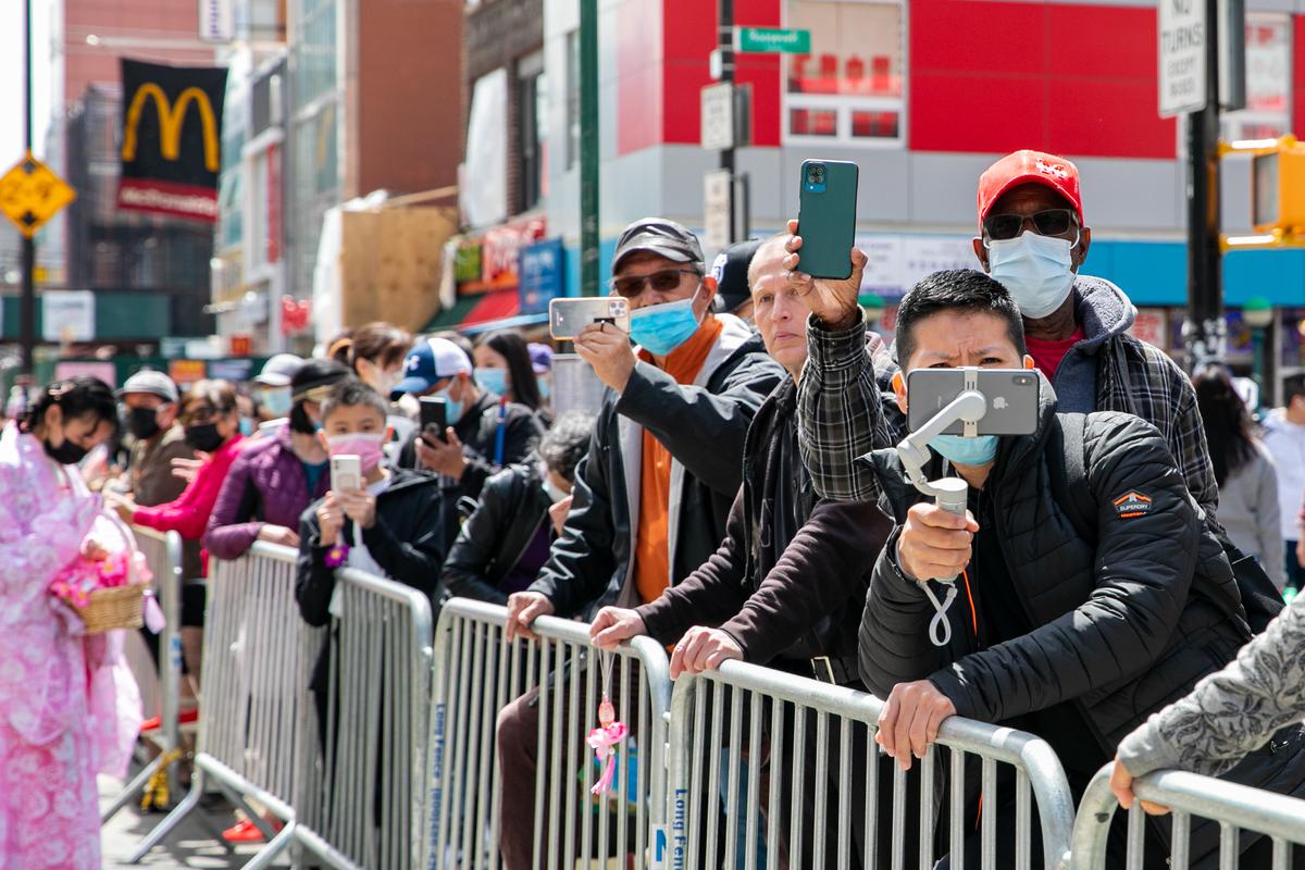 Bystanders join Falun Gong practitioners in a parade to commemorate the 23rd anniversary of the April 25th peaceful appeal of 10,000 Falun Gong practitioners in Beijing, in Flushing, N.Y., on April 23, 2022. (Chung I Ho/The Epoch Times)