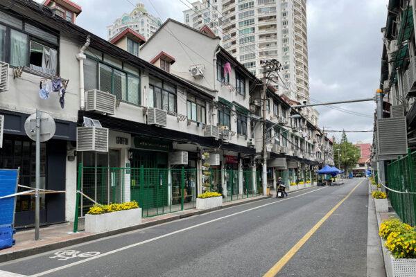 Green fences seal entrances to shops and housing units along a street in Shanghai on April 24, 2022. (Jacqueline Wong/Reuters)