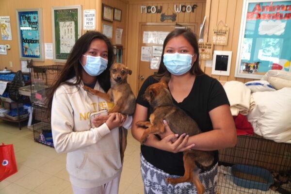 Thomasina Wero (L) and her sister Joyceline Wero pose with their two displaced dogs Carlos and Pedro at the Coconino Humane Association on April 21. (Allan Stein/The Epoch Times)