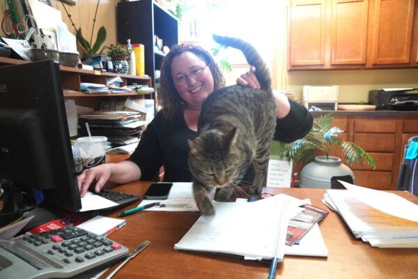 Michelle Ryan, executive director of the Coconino Humane Association in Flagstaff, Ariz., was among the hundreds forced to evacuate the Tunnel Fire. Here, she poses in her office with the family cat, Charlie. (Allan Stein/The Epoch Times)