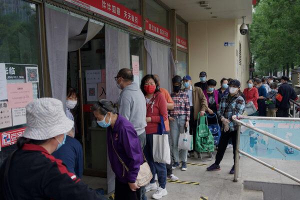 People line up outside a supermarket to buy food supplies in Beijing on April 25, 2022. (NOEL CELIS/AFP via Getty Images)
