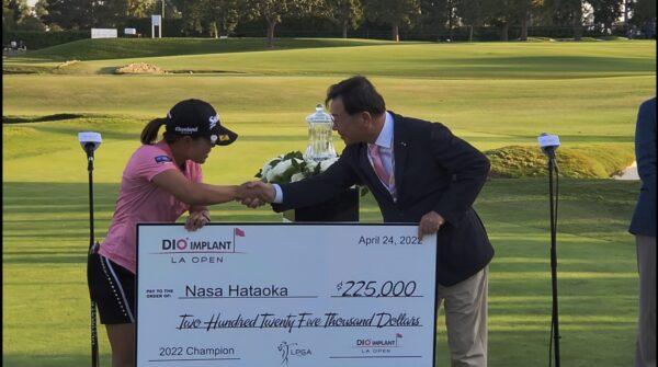 Nasa Hataoka of Japan poses for the media with DIO Implant LA Open Trophy, and DIO administrator, following her victory in the final round of the DIO Implant LA Open at Wilshire Country Club, in Los Angeles, Calif., on April 24, 2022. (Nhat Hoang/The Epoch Times)