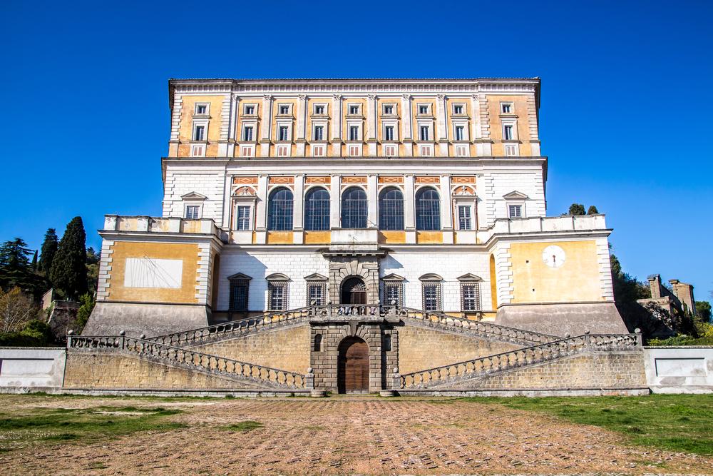 A formal double exterior stair leads to the bold arched entrance. This is flanked by bastion projections at the ends, originally designed to accommodate weaponry on top for greater defense. Five arched windows define the front façade offering a view over the town from the hall, also known as the Room of Hercules. (marcociannarel/Shutterstock)