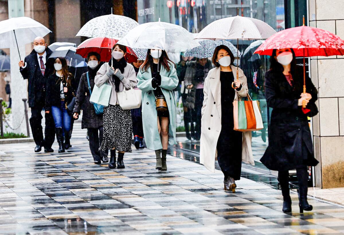 Pedestrians wearing protective face masks amid COVID-19 walk at a shopping district in Tokyo, on March 22, 2022. (Kim Kyung-Hoon/Reuters)