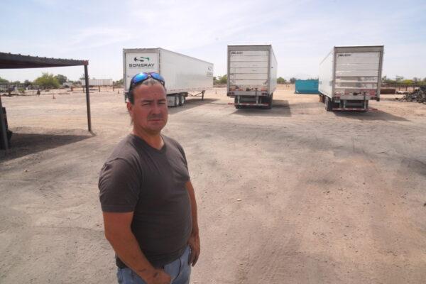 Tim Bennett, warehouse manager at the Maricopa Food Pantry, stands in front of three trailers on loan from a nearby church on April 26. (Allan Stein/The Epoch Times).