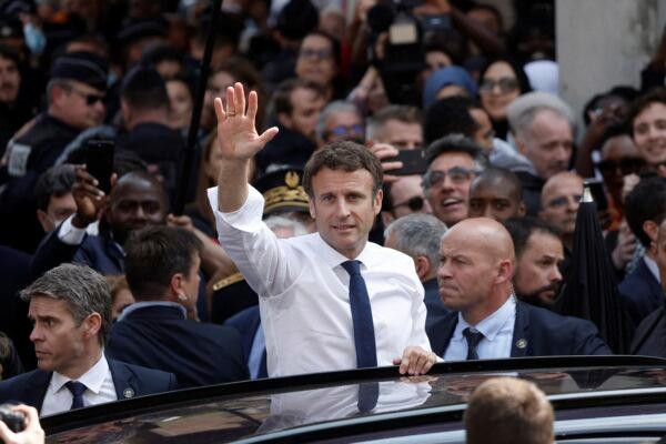 Newly reelected French President Emmanuel Macron waves from his car after his visit at the Saint-Christophe market square in Cergy, a Paris suburb, on April 27, 2022. (Benoit Tessier, Pool via AP)