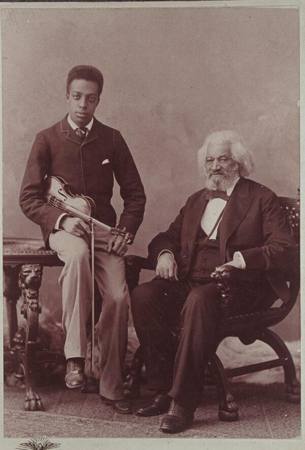 Frederick Douglass with<br/>Joseph, his grandson, who is holding a violin, circa 1894. (Public Domain)