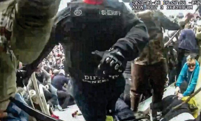 Ronald McAbee (wearing "sheriff" patch) stands at the police line on the Lower West Terrace as a Metropolitan Police Department officer (right) attacks protester Rosanne Boyland with a walking stick. (Metropolitan Police Department Bodycam/Screenshot via The Epoch Times)