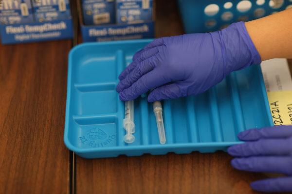 A health care worker prepares Moderna COVID-19 vaccines at a clinic in Florida on May 20, 2021. (Joe Raedle/Getty Images)