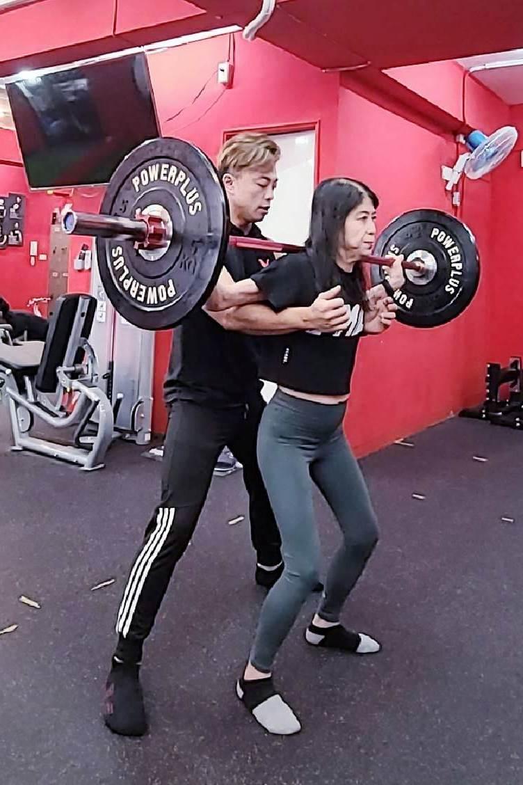 Jung-Hua Chen exercises in the gym with the help of her son, also the fitness coach, Daniel. (Courtesy of Daniel, founder of FMC Fitness Space)