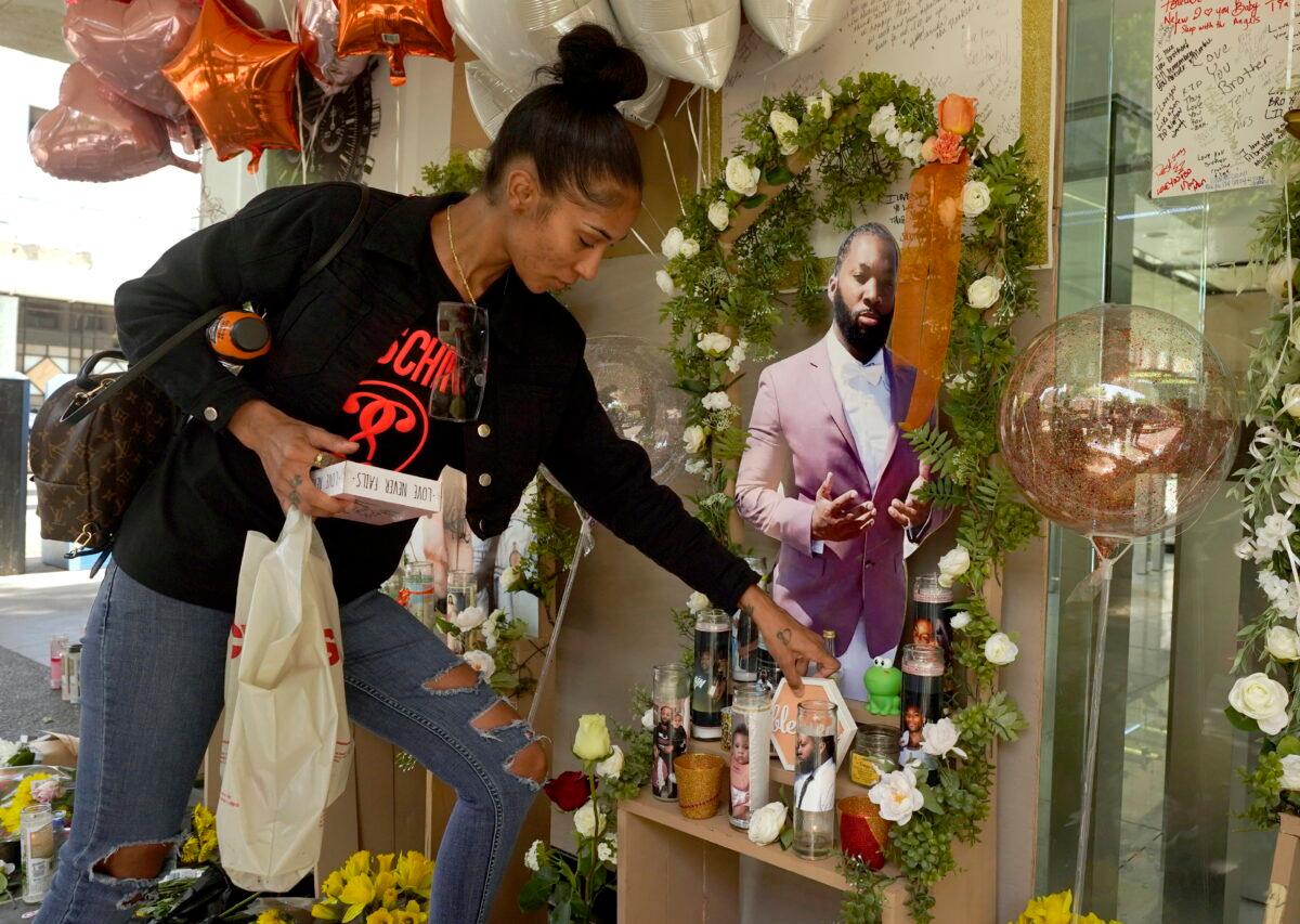 Kay Harris, the sister of shooting victim Sergio Harris, places a decoration by a photo of her slain brother at a memorial in Sacramento, Calif., on April 7, 2022. (Rich Pedroncelli/AP Photo)