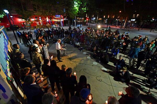 Sacramento Mayor Darrell Steinberg reads the names of the shooting victims during a candlelight vigil held at Ali Youssefi Square in Sacramento, Calif., on April 4, 2022. (Jose Carlos Fajardo/Bay Area News Group via AP)
